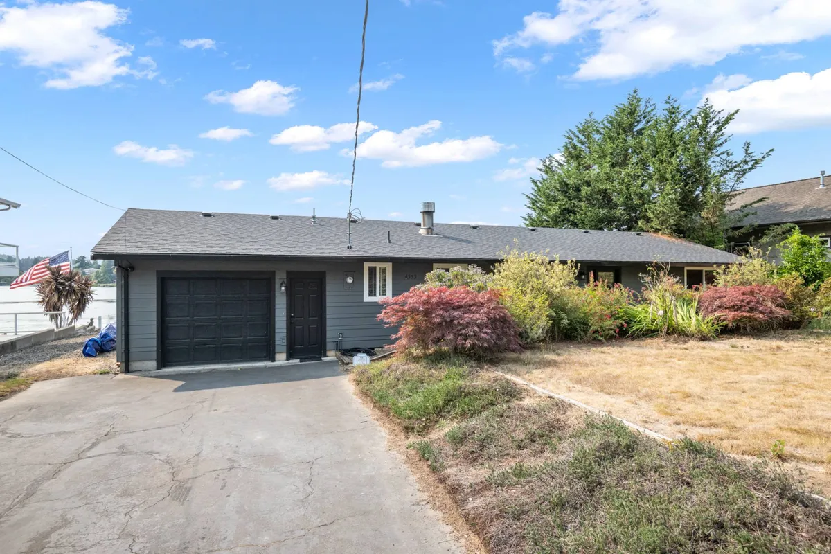 The image showcases the welcoming facade of the house, complemented by a lush garden and a driveway that hints at family arrivals and departures. The inviting porch suggests a space that fosters togetherness, relaxation, and transitions between outdoor adventures and cozy indoor activities.